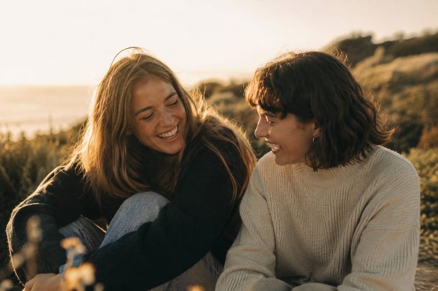 Two friends laughing together at golden hour